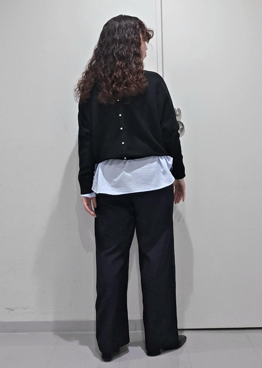 ブラック系のパンプス、ブラック系のニット/セーター、ブルー系のその他パンツを着用したレディースの冬コーディネートの7枚目の写真