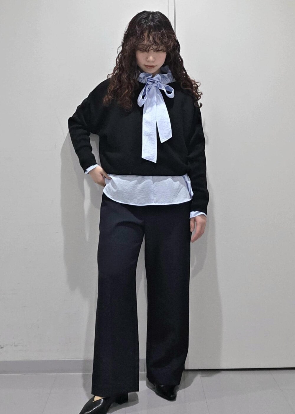 ブラック系のパンプス、ブラック系のニット/セーター、ブルー系のその他パンツを着用したレディースの冬コーディネートの2枚目の写真