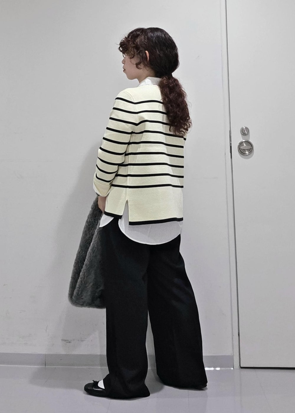 ホワイト系のシャツ/ブラウス、ホワイト系のニット/セーター、ブルー系のスラックスを着用したレディースの秋コーディネートの6枚目の写真