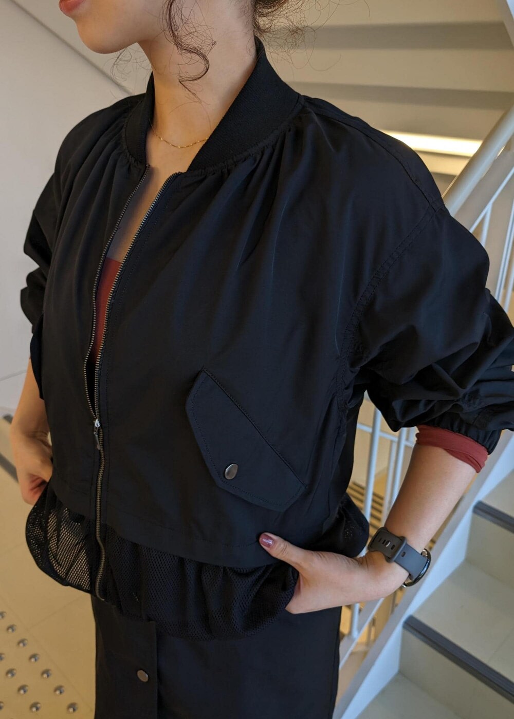 レッド系のTシャツ/カットソー、ブラック系のスニーカー、ブラック系のブルゾンを着用したレディースの春コーディネートの6枚目の写真
