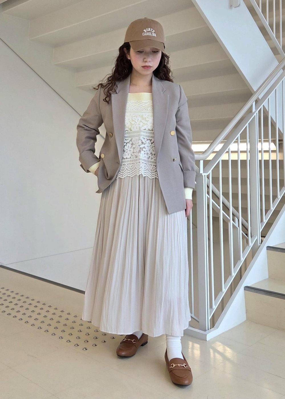 イエロー系のローファー、ベージュ系のテーラードジャケット、ベージュ系のニット/セーターを着用したレディースの春コーディネートの8枚目の写真