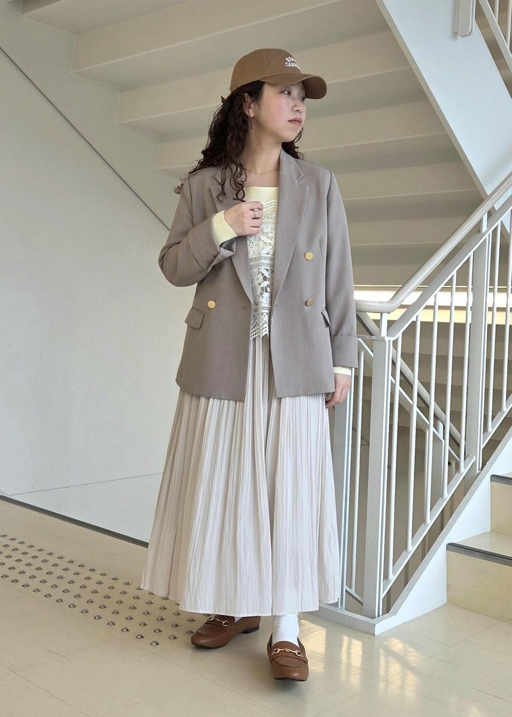 イエロー系のローファー、ベージュ系のテーラードジャケット、ベージュ系のニット/セーターを着用したレディースの春コーディネートの5枚目の写真