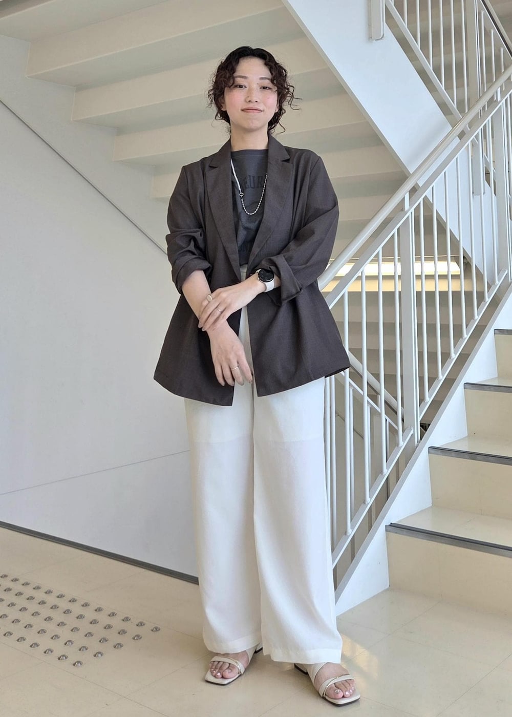 ブラウン系のテーラードジャケット、グレー系のTシャツ/カットソー、ホワイト系のその他パンツを着用したレディースの夏コーディネートの4枚目の写真