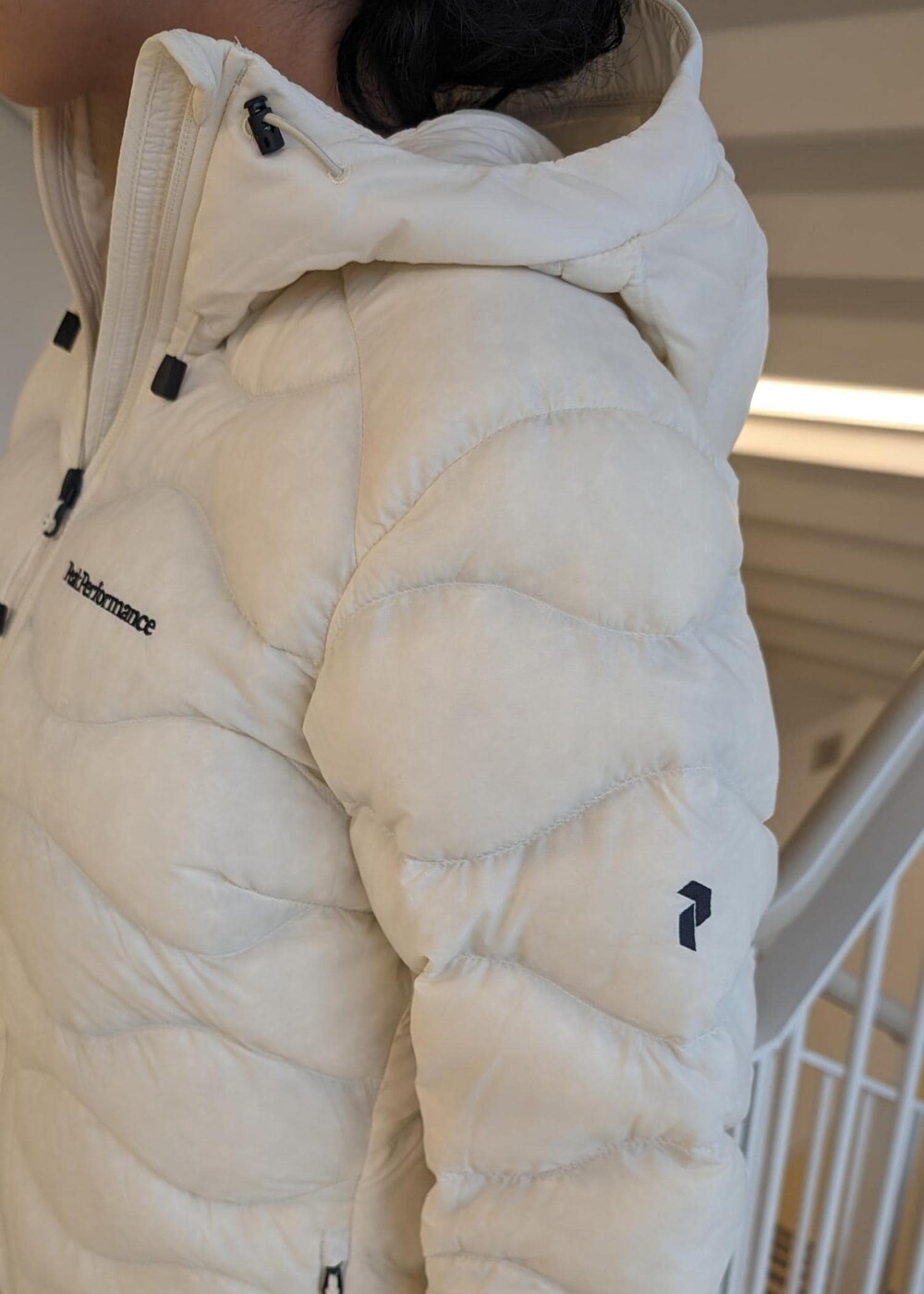 ホワイト系のスカート、ホワイト系のダウンジャケット/コート、ブラック系のTシャツ/カットソーを着用したレディースの冬コーディネートの7枚目の写真