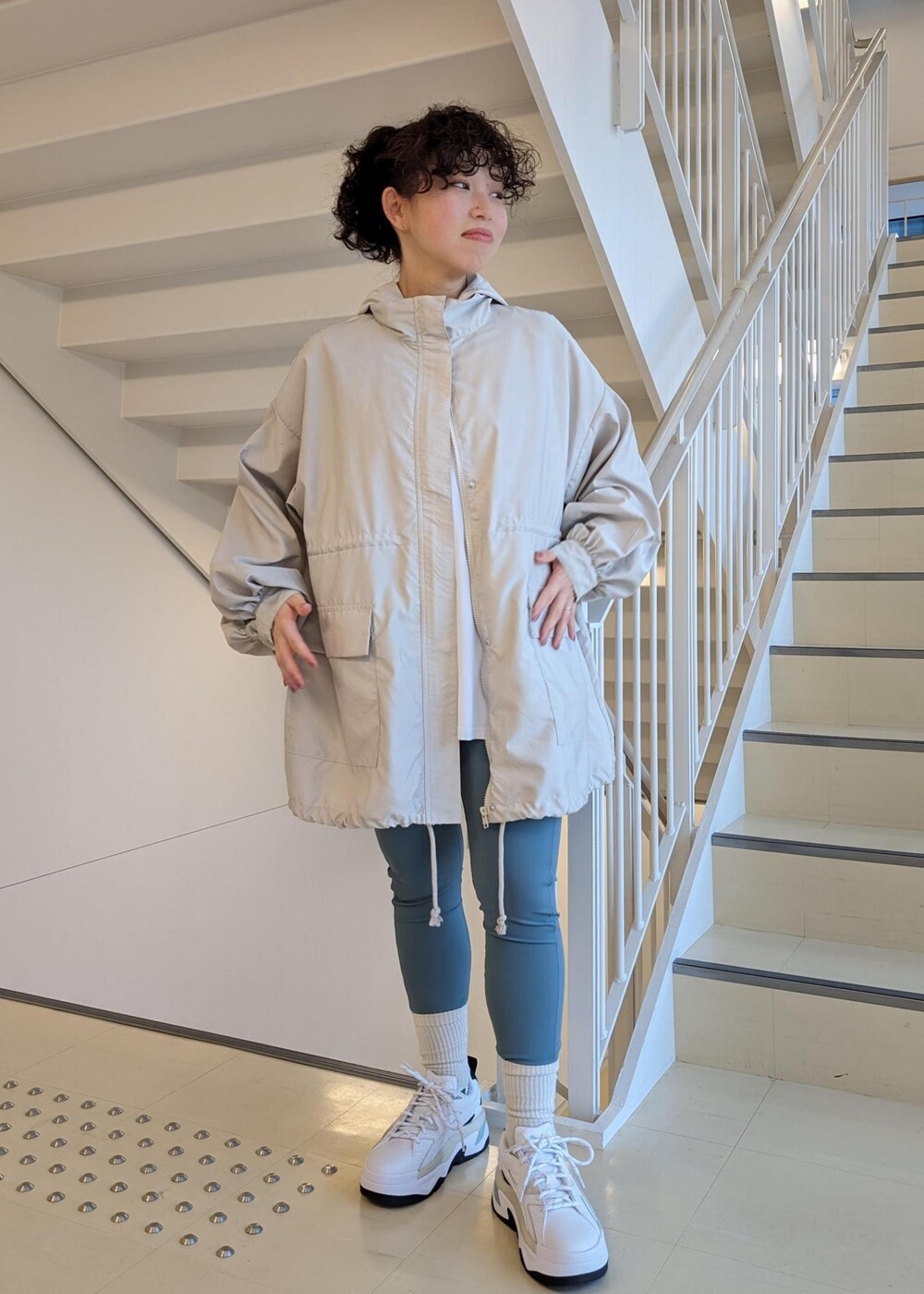 ホワイト系のスニーカー、ホワイト系のTシャツ/カットソー、ブルー系のレギンス/スパッツを着用したレディースの春コーディネートの3枚目の写真