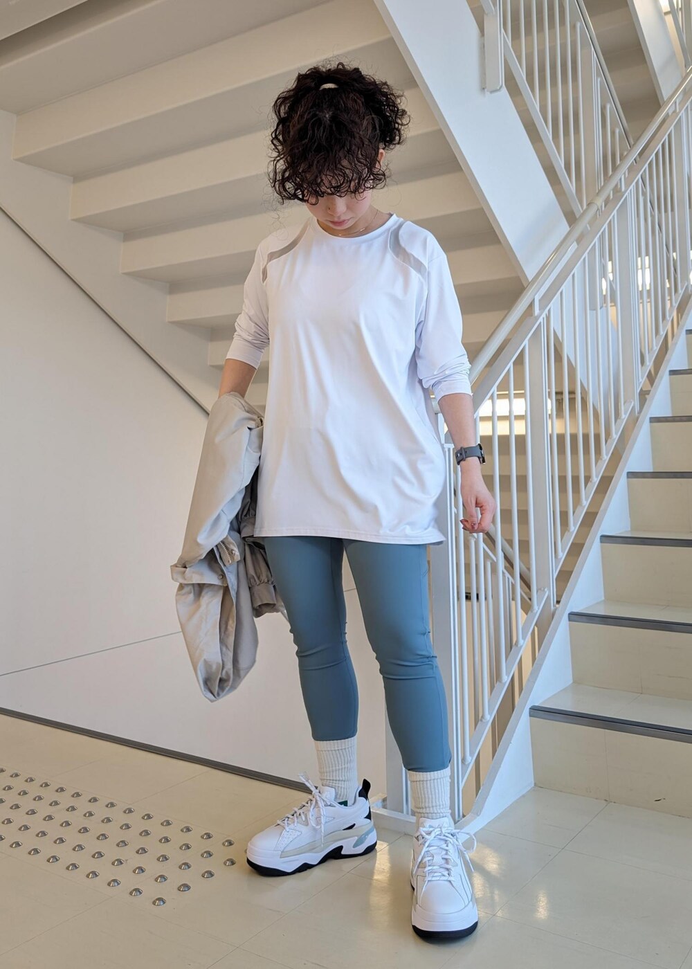 ホワイト系のスニーカー、ホワイト系のTシャツ/カットソー、ブルー系のレギンス/スパッツを着用したレディースの春コーディネートの2枚目の写真