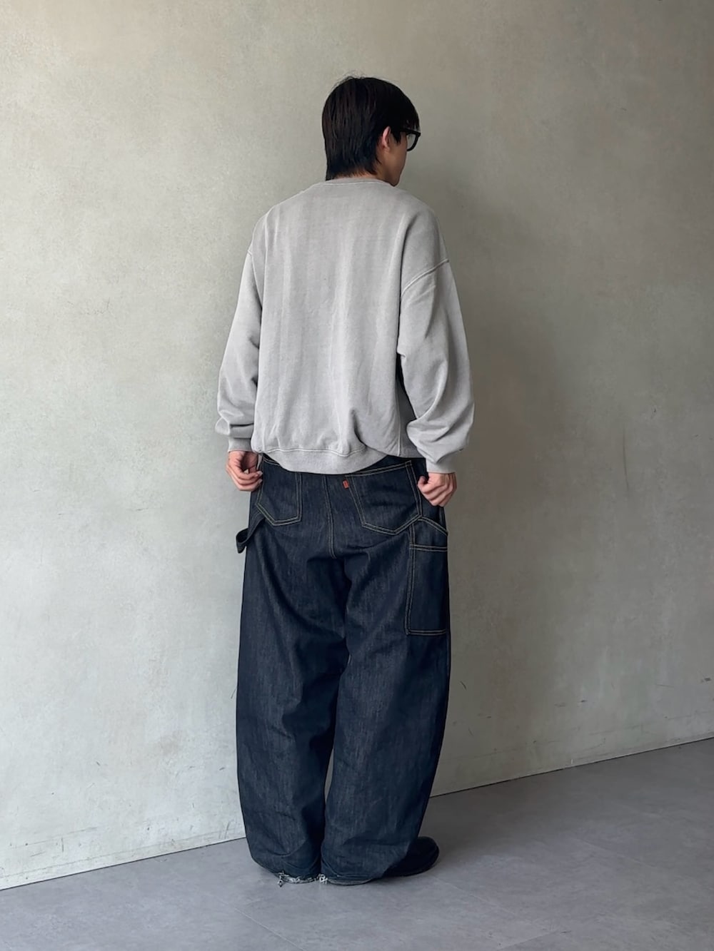 グレー系のTシャツ/カットソー、ブルー系のデニムパンツを着用したメンズの秋コーディネートの3枚目の写真