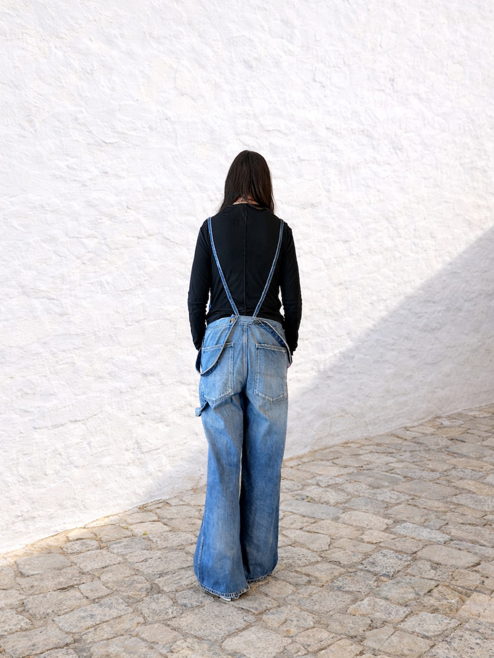 ブラック系のジャケット/アウター、ブルー系のサロペット/オーバーオール、その他のスニーカーを着用したレディースの冬コーディネートの3枚目の写真