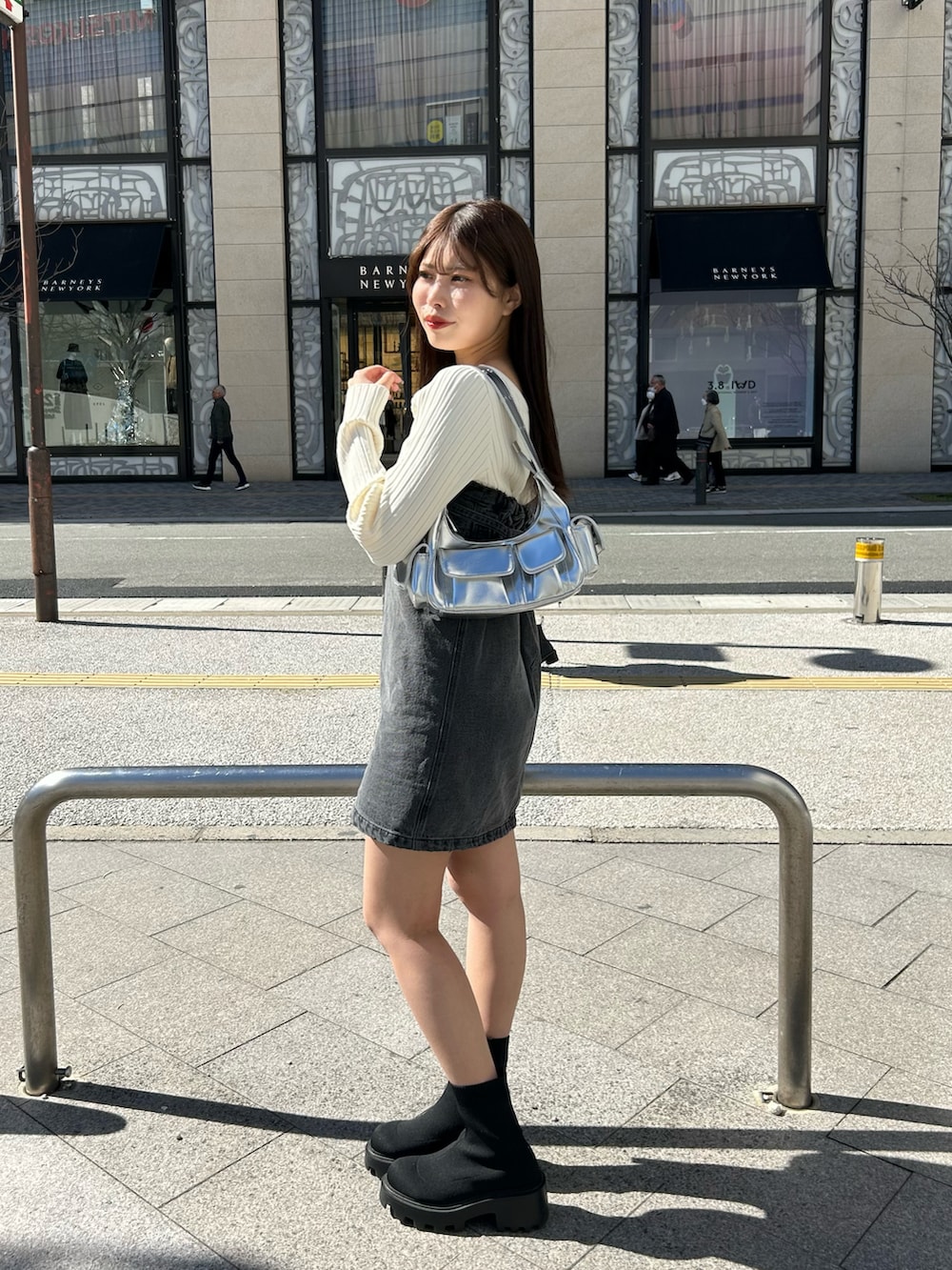 ホワイト系のニット/セーター、シルバー系のショルダーバッグ、ブラック系のブーツを着用したレディースの春コーディネートの2枚目の写真