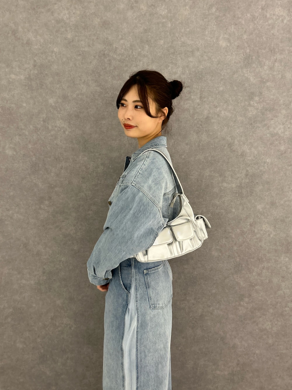 ブルー系のデニムパンツ、ブルー系のデニムジャケット、ホワイト系のキャミソールを着用したレディースの冬コーディネートの4枚目の写真