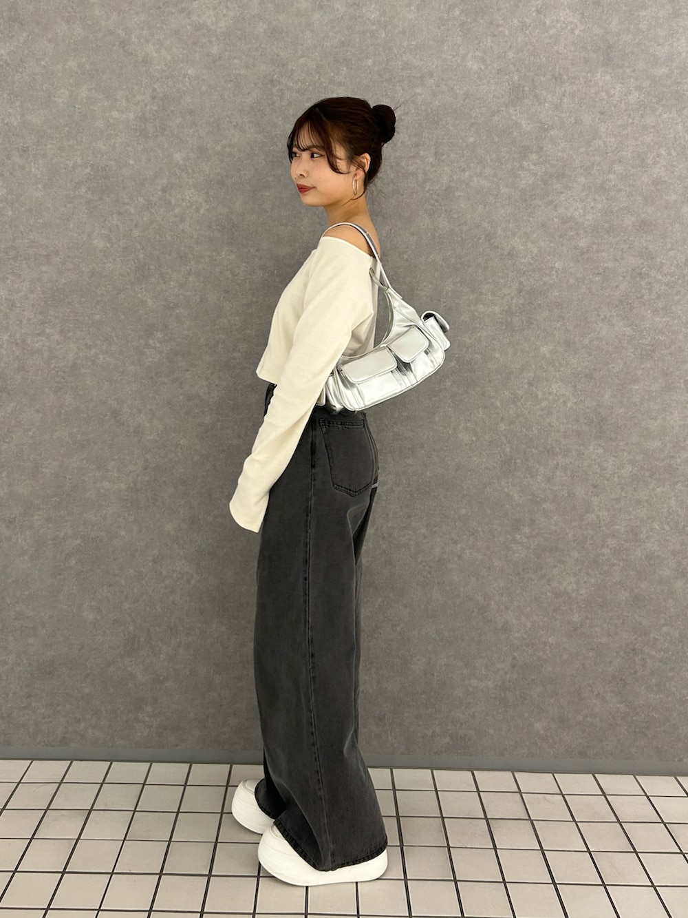 ホワイト系のTシャツ/カットソー、グレー系のデニムパンツ、ホワイト系のスニーカーを着用したレディースの冬コーディネートの4枚目の写真