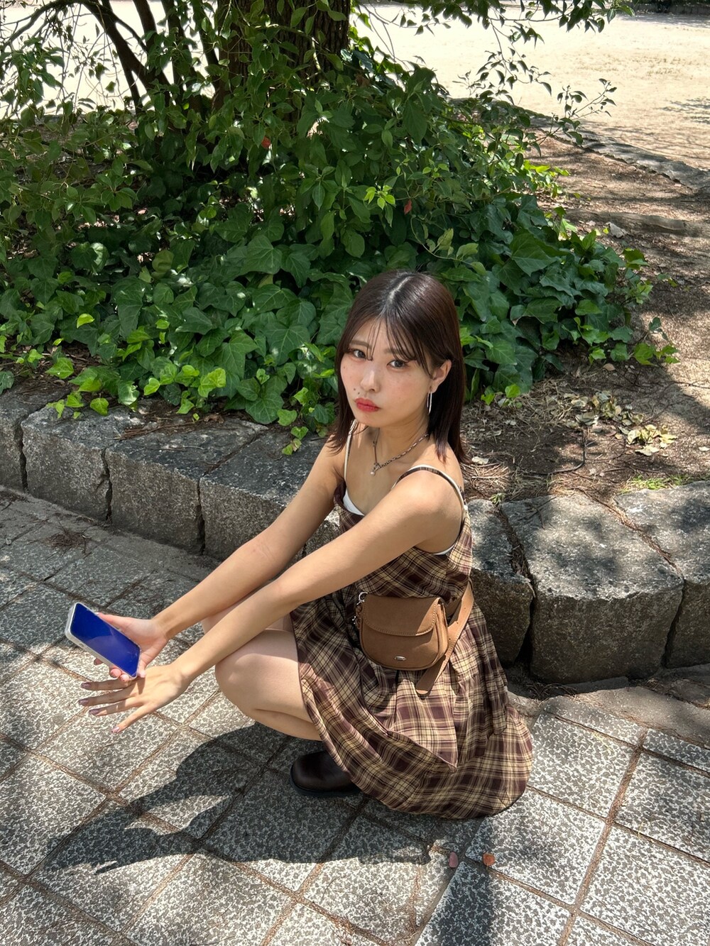 ブラウン系のワンピース、ブラウン系のブーツ、ホワイト系のキャミソールを着用したレディースの夏コーディネートの6枚目の写真