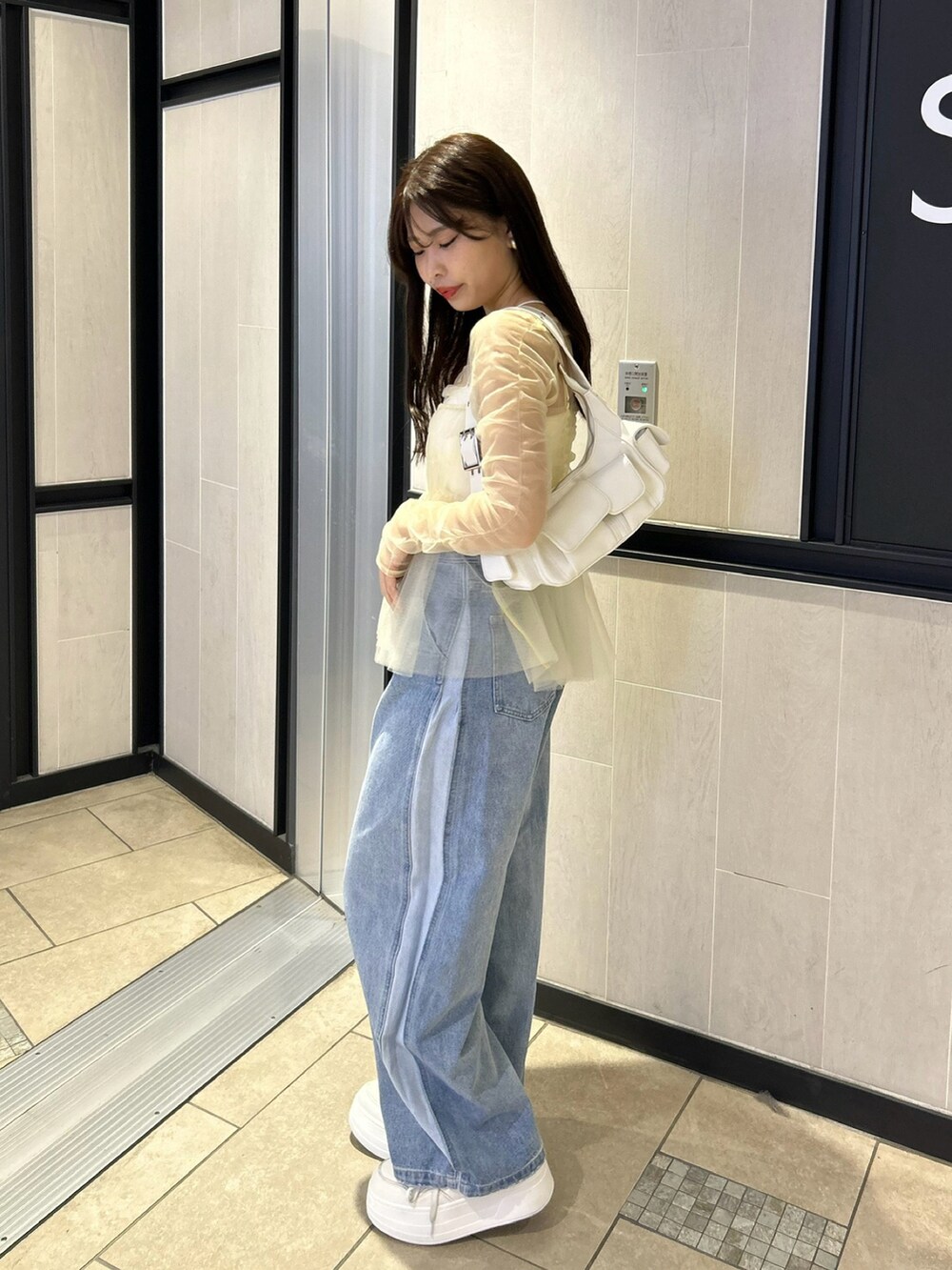 ブルー系のデニムパンツ、ホワイト系のシャツ/ブラウス、ホワイト系のキャミソールを着用したレディースの冬コーディネートの2枚目の写真