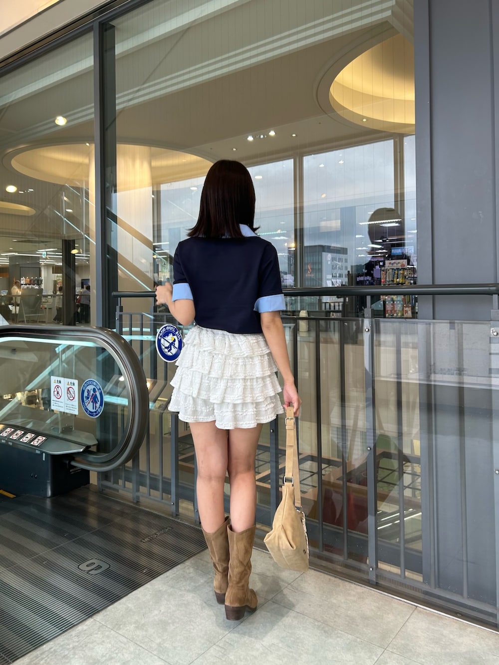 ブルー系のニット/セーター、ホワイト系のその他パンツ、ベージュ系のショルダーバッグを着用したレディースの春コーディネートの3枚目の写真