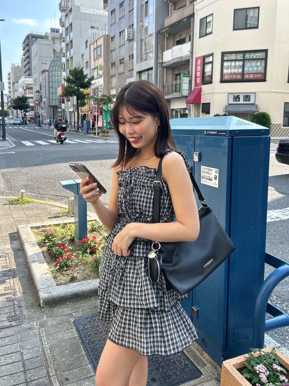 ブラック系のワンピース、ブラック系のブーツ、ブラック系のショルダーバッグを着用したレディースの夏コーディネートの5枚目の写真