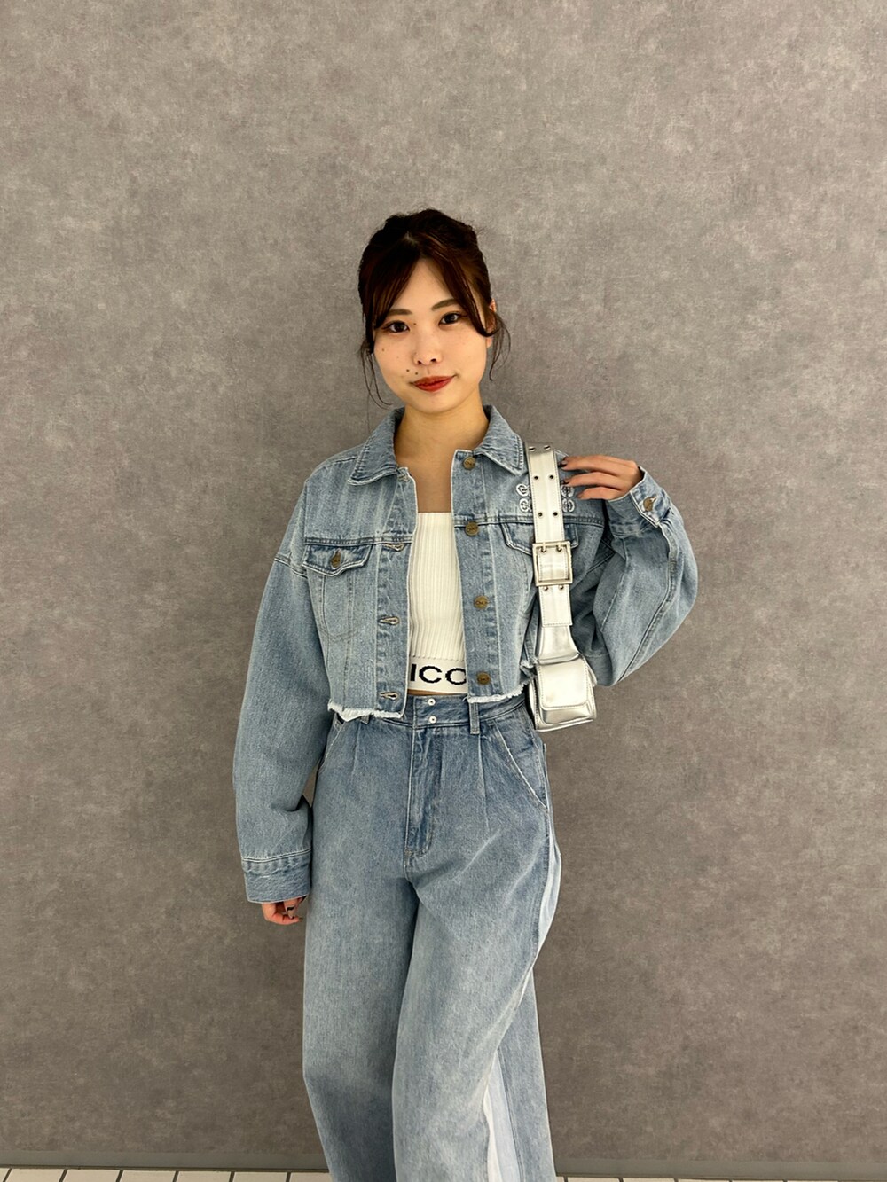 ブルー系のデニムパンツ、ブルー系のデニムジャケット、ホワイト系のキャミソールを着用したレディースの冬コーディネートの3枚目の写真