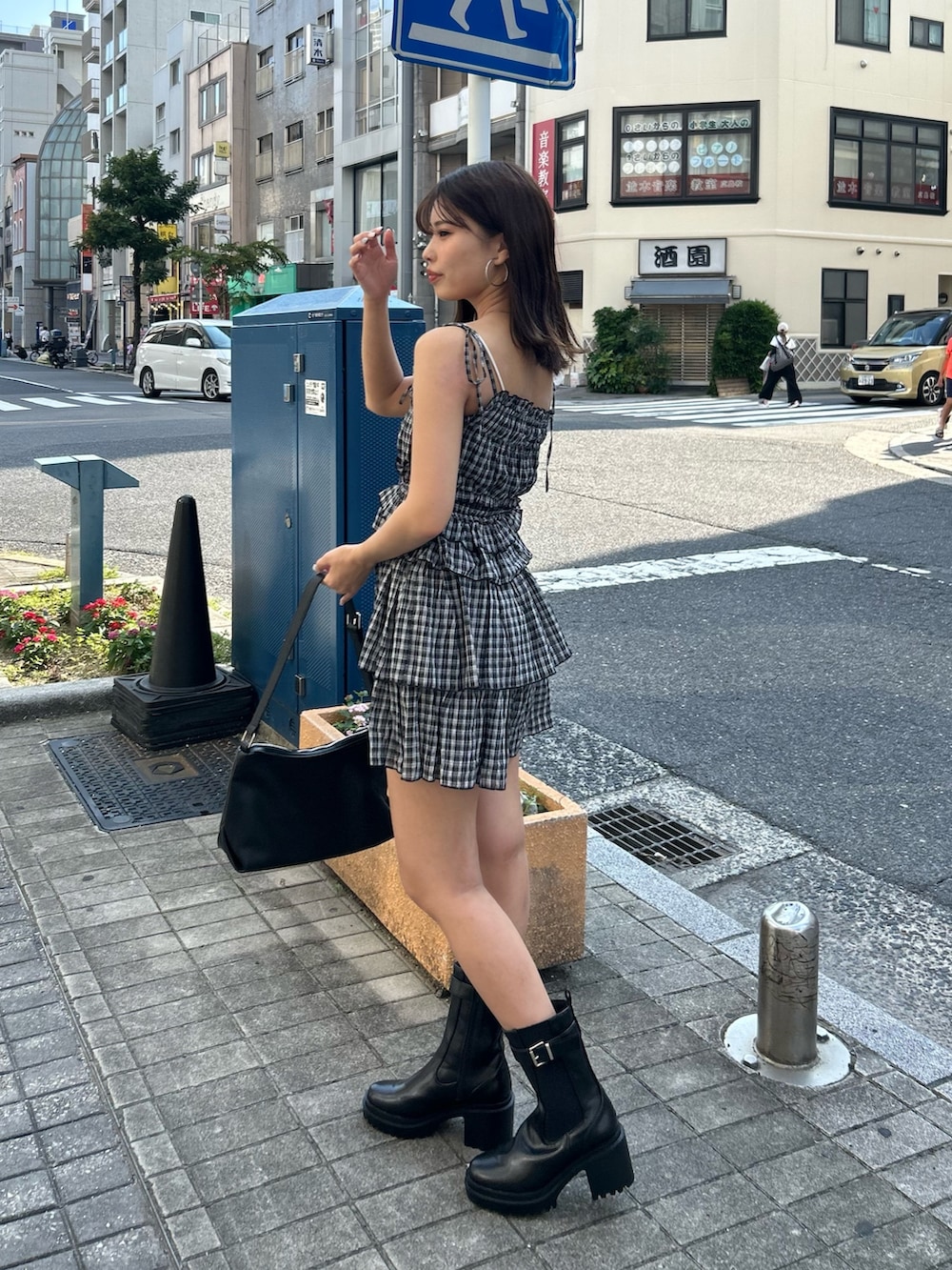 ブラック系のワンピース、ブラック系のブーツ、ブラック系のショルダーバッグを着用したレディースの夏コーディネートの2枚目の写真