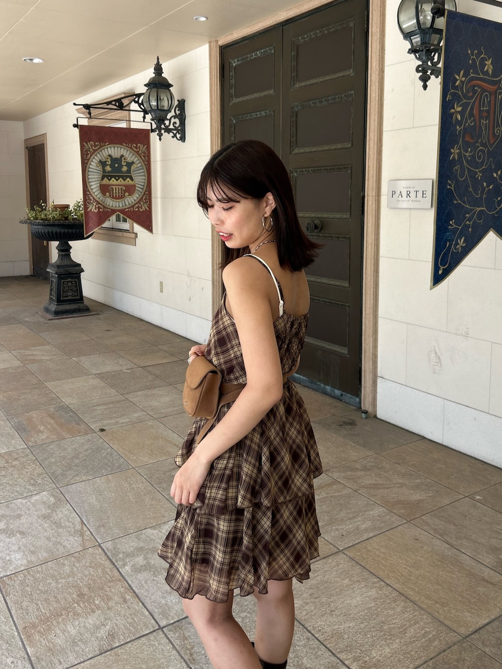 ブラウン系のワンピース、ブラウン系のブーツ、ホワイト系のキャミソールを着用したレディースの夏コーディネートの5枚目の写真