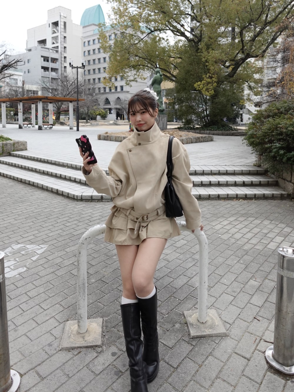 ホワイト系のその他アウター、ベージュ系のスカート、ブラック系のブーツを着用したレディースの冬コーディネートの4枚目の写真