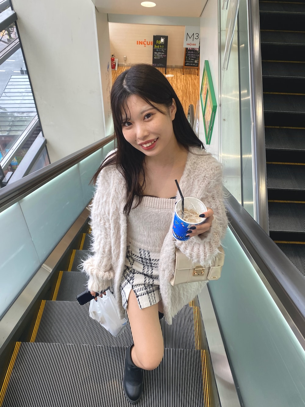 ホワイト系のショルダーバッグ、ホワイト系のカーディガン/ボレロ、ホワイト系のキャミソールを着用したレディースの秋コーディネートの3枚目の写真