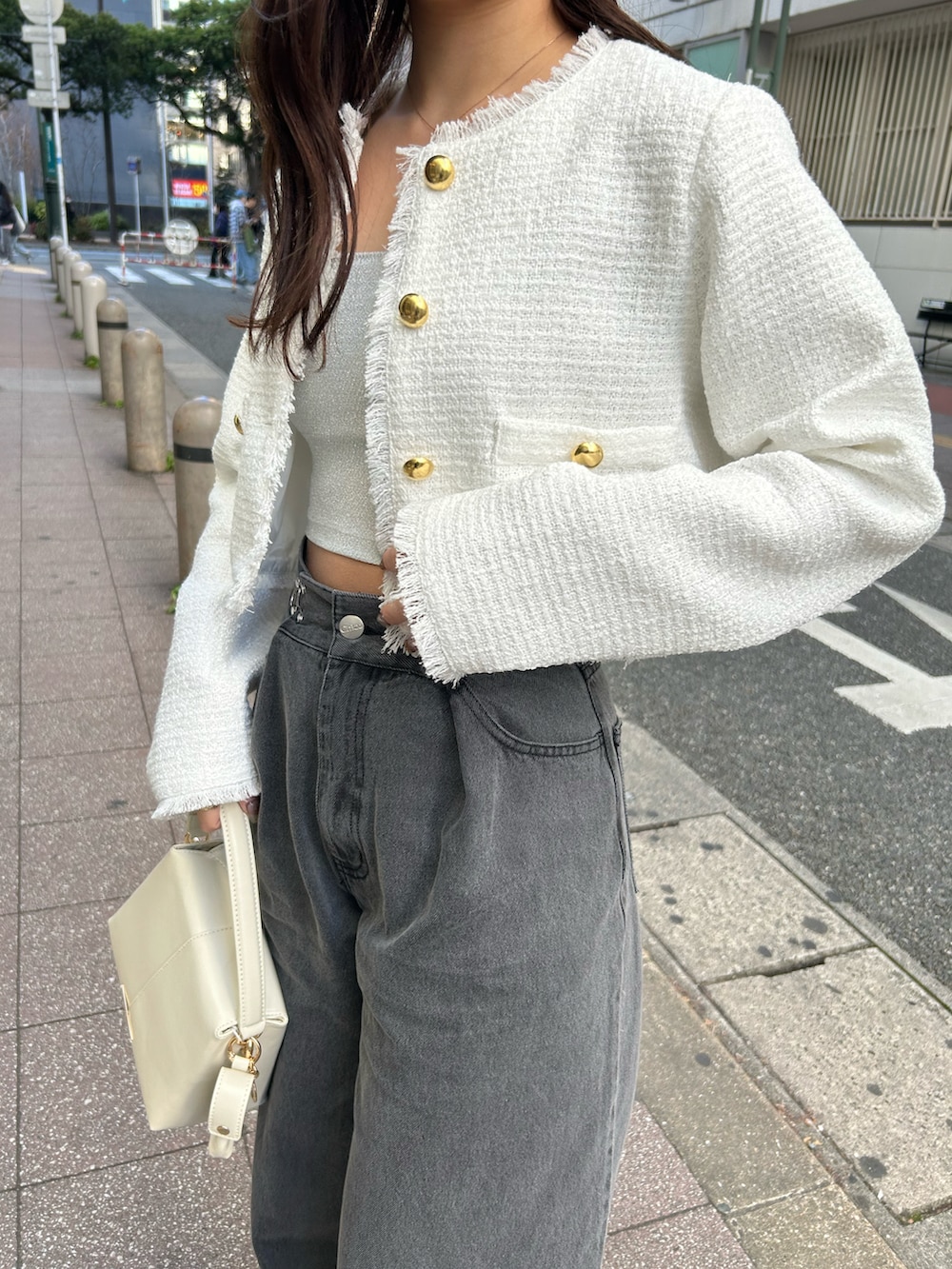 グレー系のデニムパンツ、ホワイト系のノーカラージャケット、ホワイト系のショルダーバッグを着用したレディースの冬コーディネートの4枚目の写真