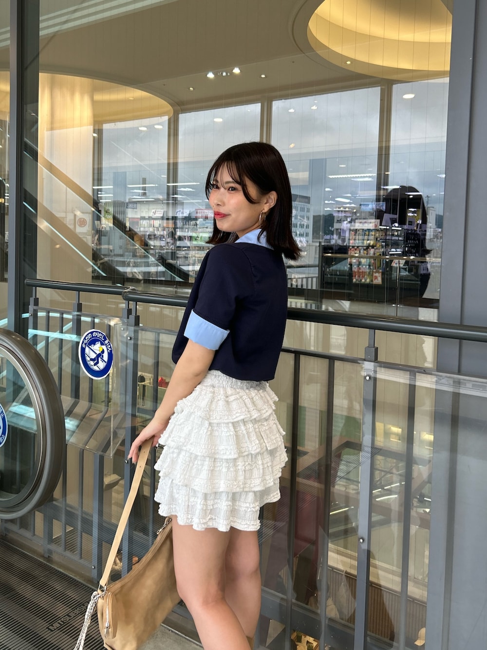 ブルー系のニット/セーター、ホワイト系のその他パンツ、ベージュ系のショルダーバッグを着用したレディースの春コーディネートの5枚目の写真