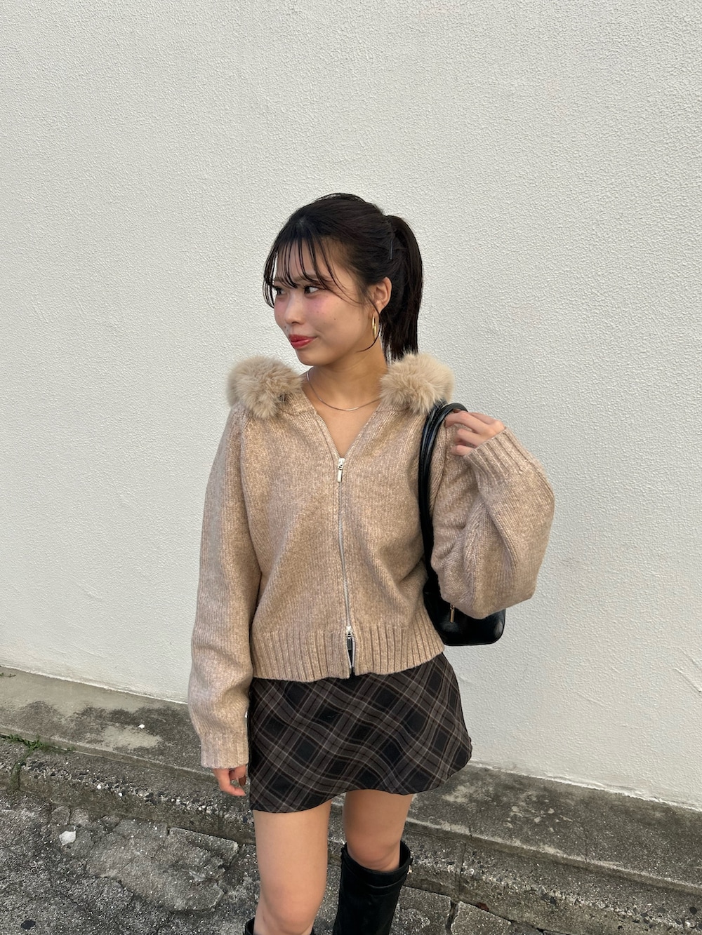 ベージュ系のニット/セーター、グレー系のスカート、ブラック系のボストンバッグを着用したレディースの秋コーディネートの4枚目の写真