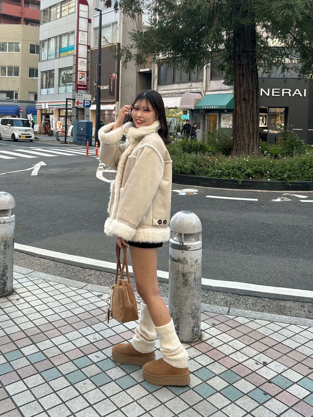 ホワイト系のその他アウター、ブラウン系のその他パンツ、ブラウン系のボストンバッグを着用したレディースの秋コーディネートの2枚目の写真