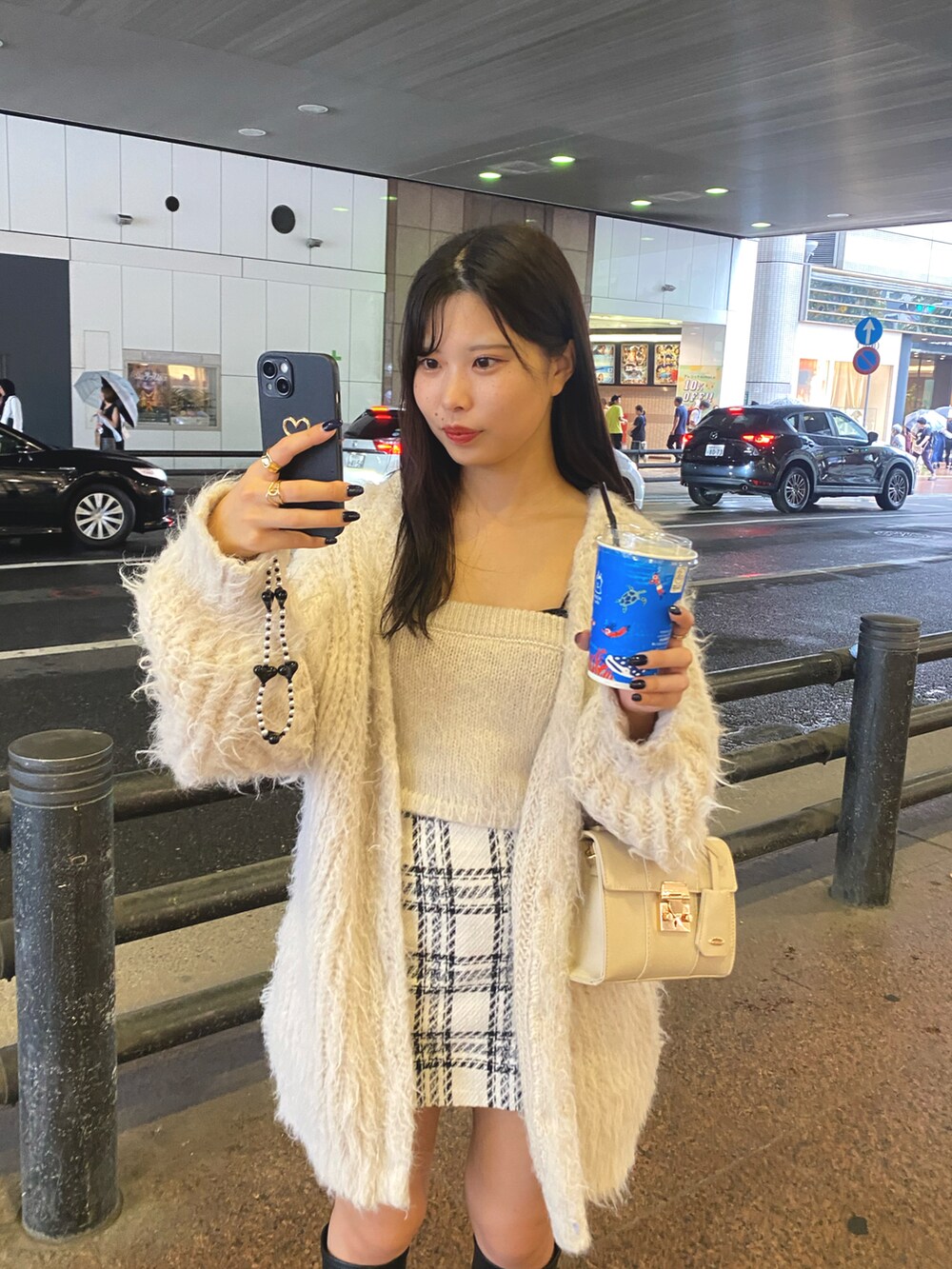 ホワイト系のショルダーバッグ、ホワイト系のカーディガン/ボレロ、ホワイト系のキャミソールを着用したレディースの秋コーディネートの4枚目の写真