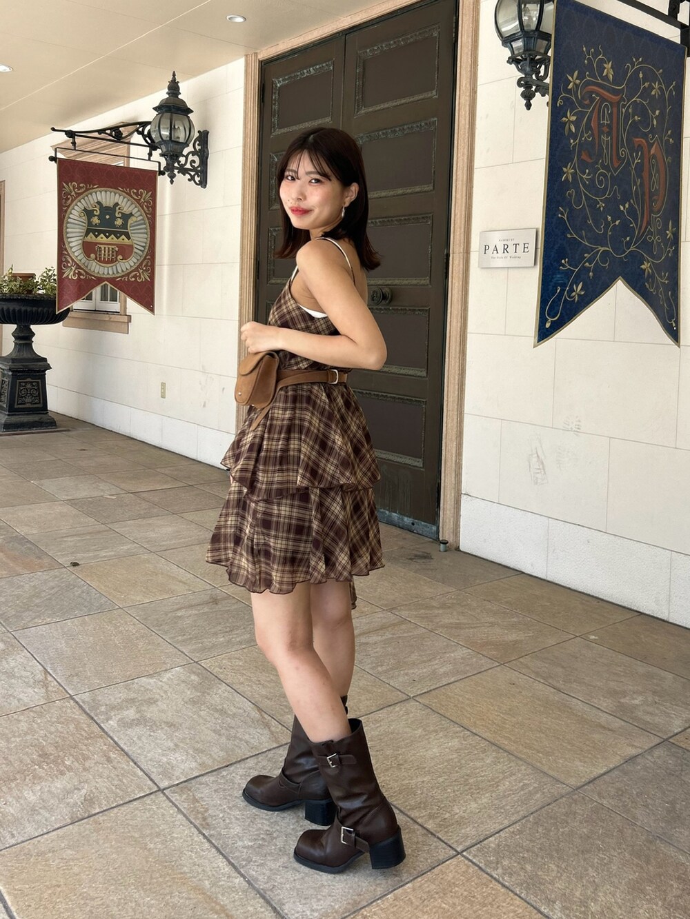 ブラウン系のワンピース、ブラウン系のブーツ、ホワイト系のキャミソールを着用したレディースの夏コーディネートの3枚目の写真