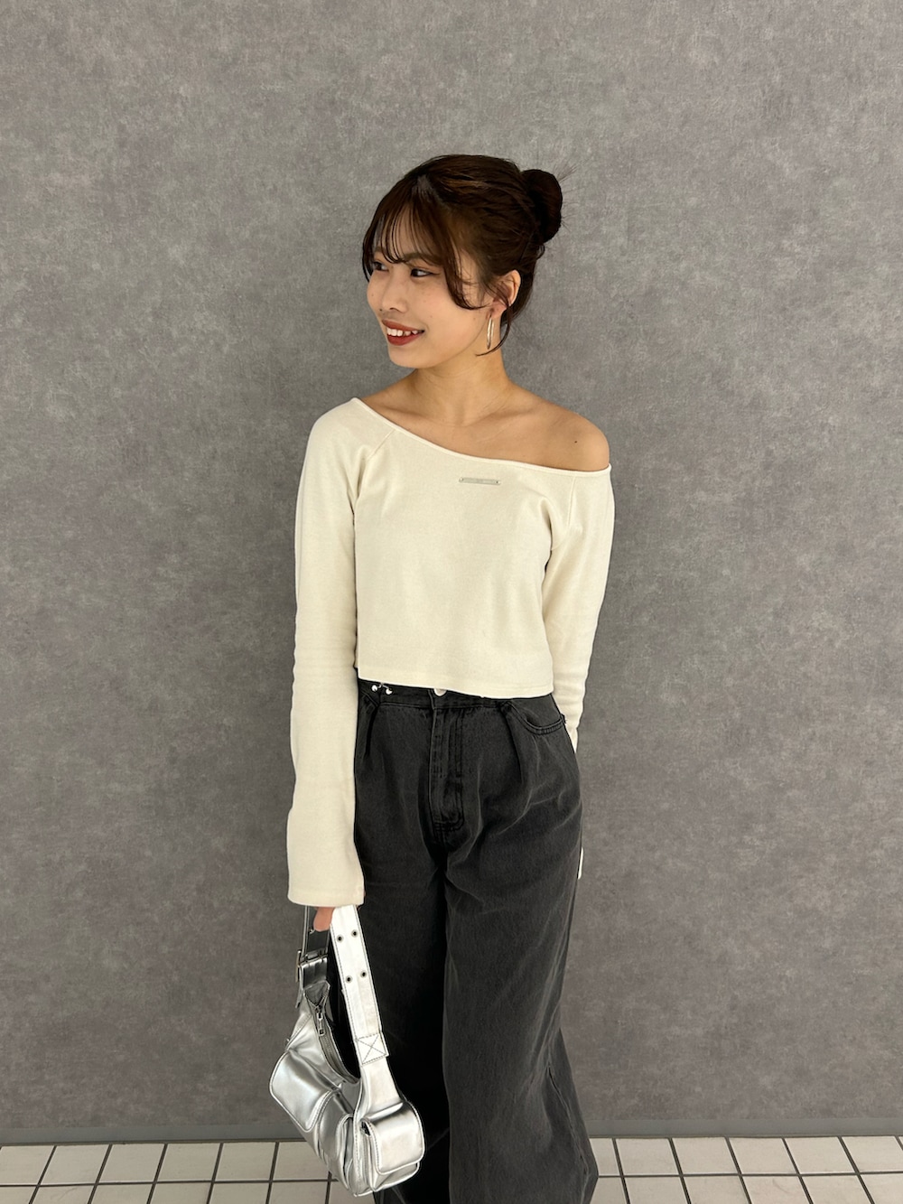 ホワイト系のTシャツ/カットソー、グレー系のデニムパンツ、ホワイト系のスニーカーを着用したレディースの冬コーディネートの3枚目の写真