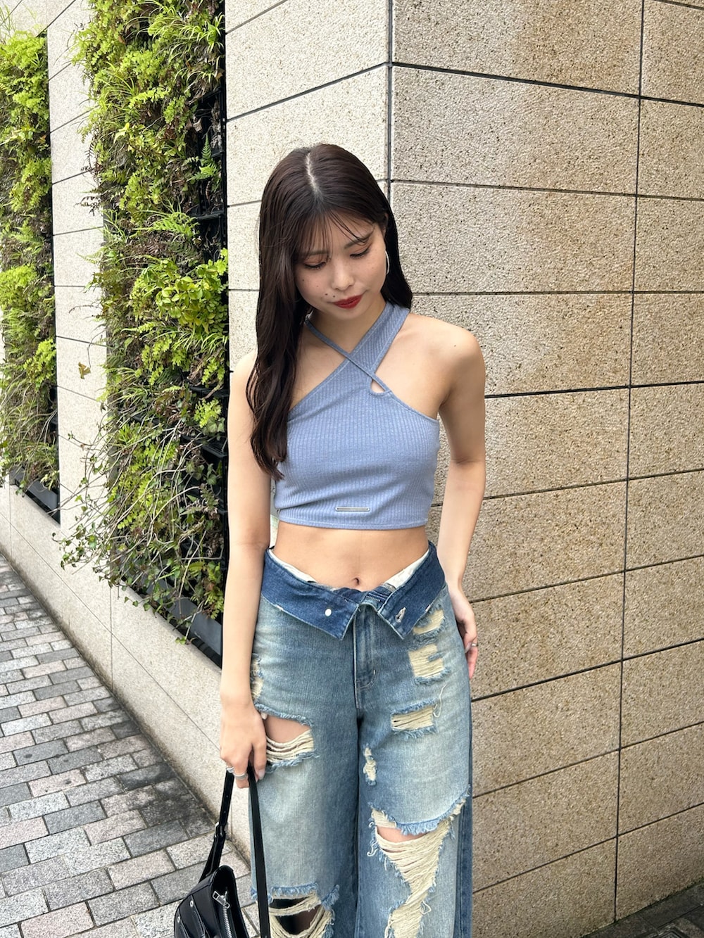 ブルー系のデニムパンツ、ブラック系のショルダーバッグ、ブラック系のサンダルを着用したレディースの春コーディネートの3枚目の写真