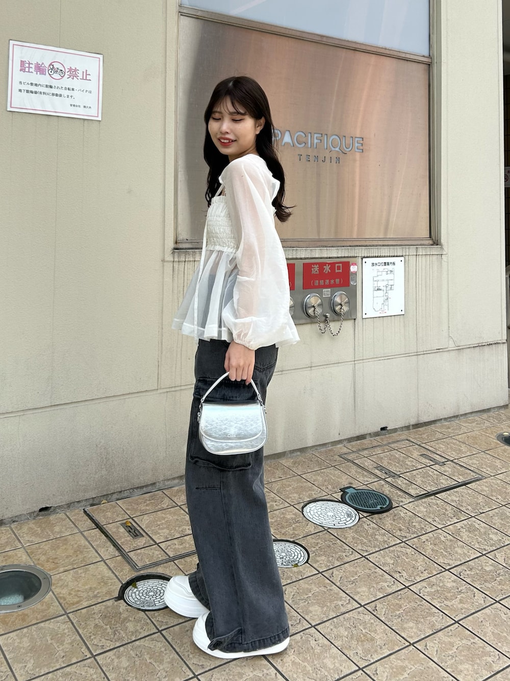 グレー系のデニムパンツ、ホワイト系のシャツ/ブラウス、ホワイト系のスニーカーを着用したレディースの春コーディネートの2枚目の写真