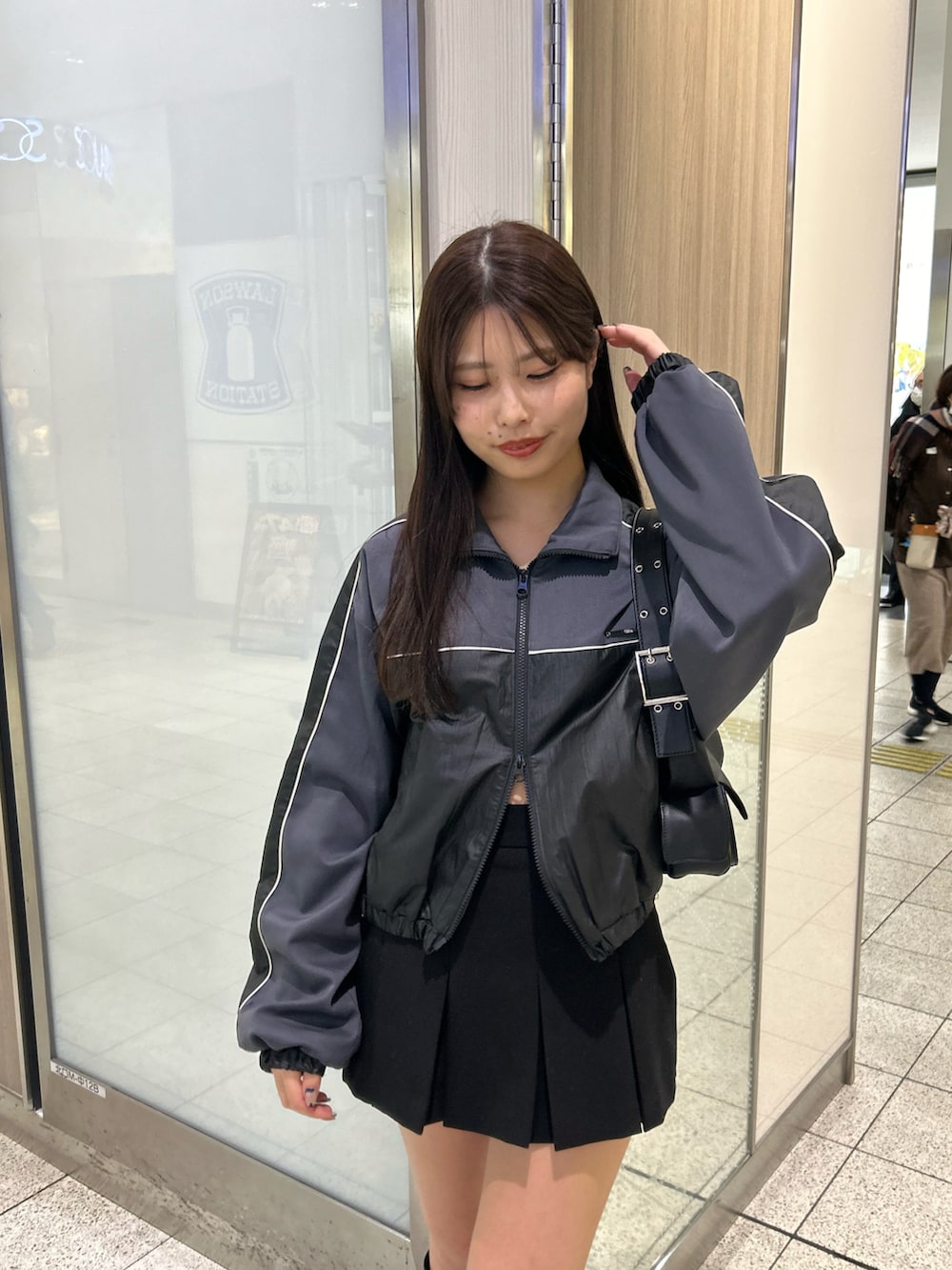 グレー系のブルゾン、ブラック系のブーツ、ブラック系のスカートを着用したレディースの冬コーディネートの3枚目の写真