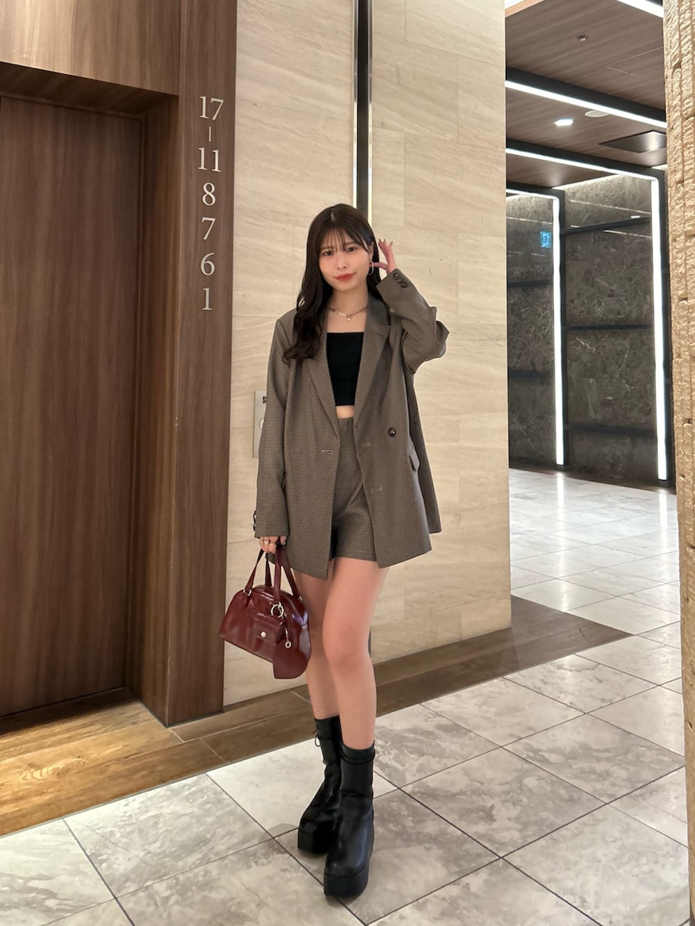 ブラウン系のテーラードジャケット、ブラウン系のその他パンツ、レッド系のボストンバッグを着用したレディースの夏コーディネートの3枚目の写真