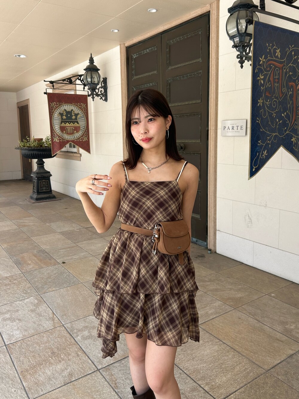 ブラウン系のワンピース、ブラウン系のブーツ、ホワイト系のキャミソールを着用したレディースの夏コーディネートの4枚目の写真