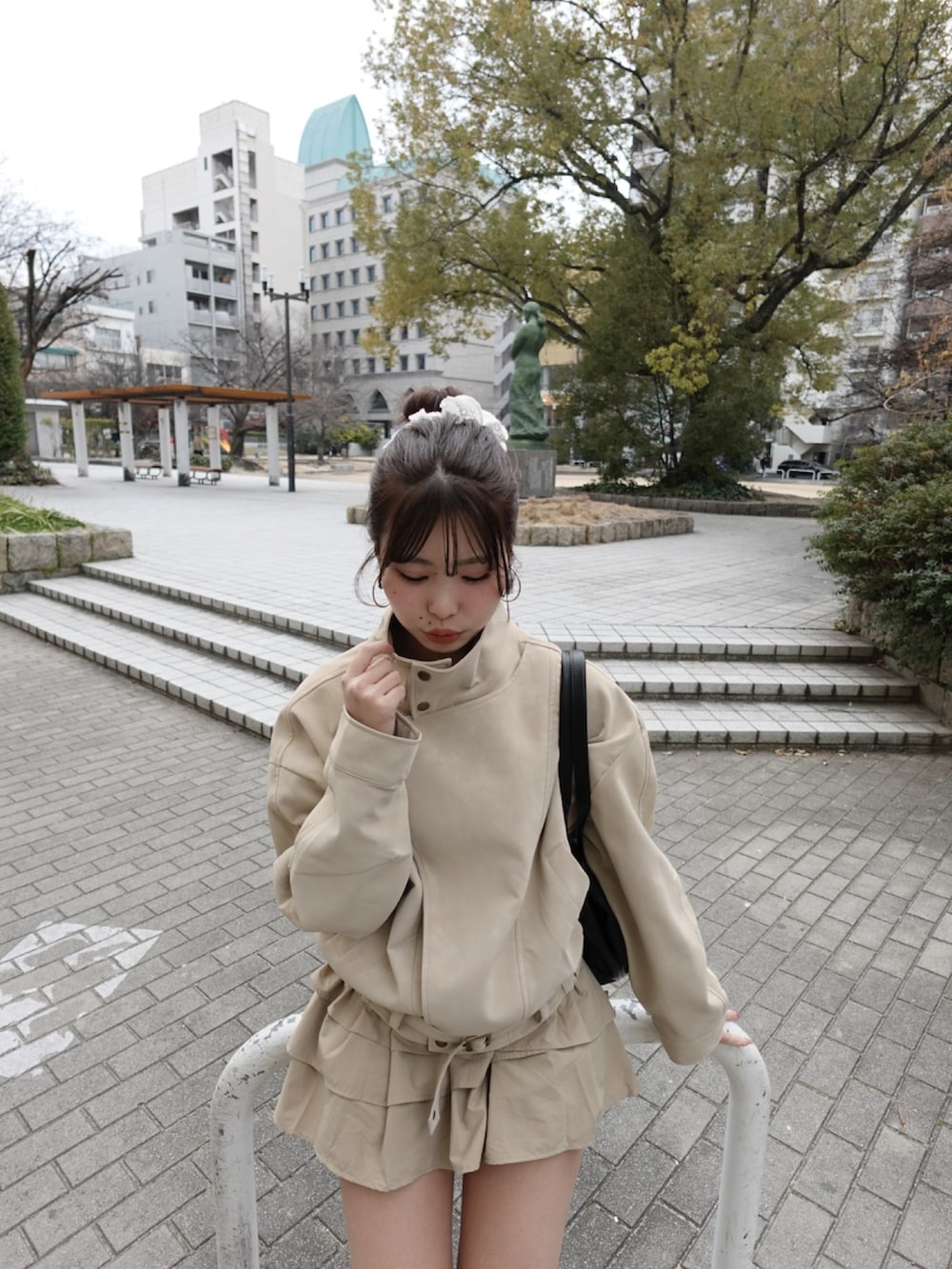 ホワイト系のその他アウター、ベージュ系のスカート、ブラック系のブーツを着用したレディースの冬コーディネートの2枚目の写真