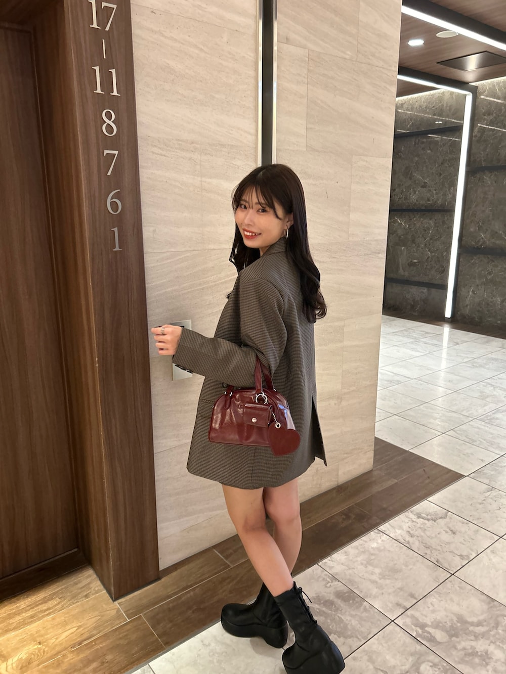 ブラウン系のテーラードジャケット、ブラウン系のその他パンツ、レッド系のボストンバッグを着用したレディースの夏コーディネートの4枚目の写真