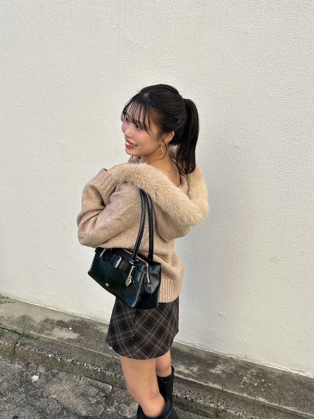 ベージュ系のニット/セーター、グレー系のスカート、ブラック系のボストンバッグを着用したレディースの秋コーディネートの5枚目の写真