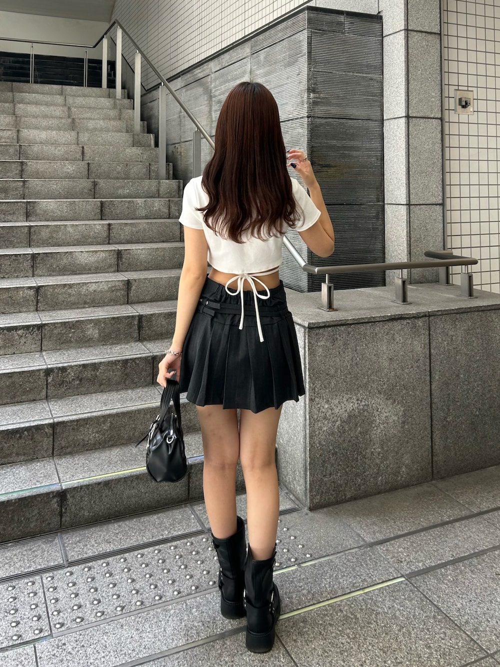 ホワイト系のTシャツ/カットソー、グレー系のスカート、ブラック系のボストンバッグを着用したレディースの夏コーディネートの3枚目の写真