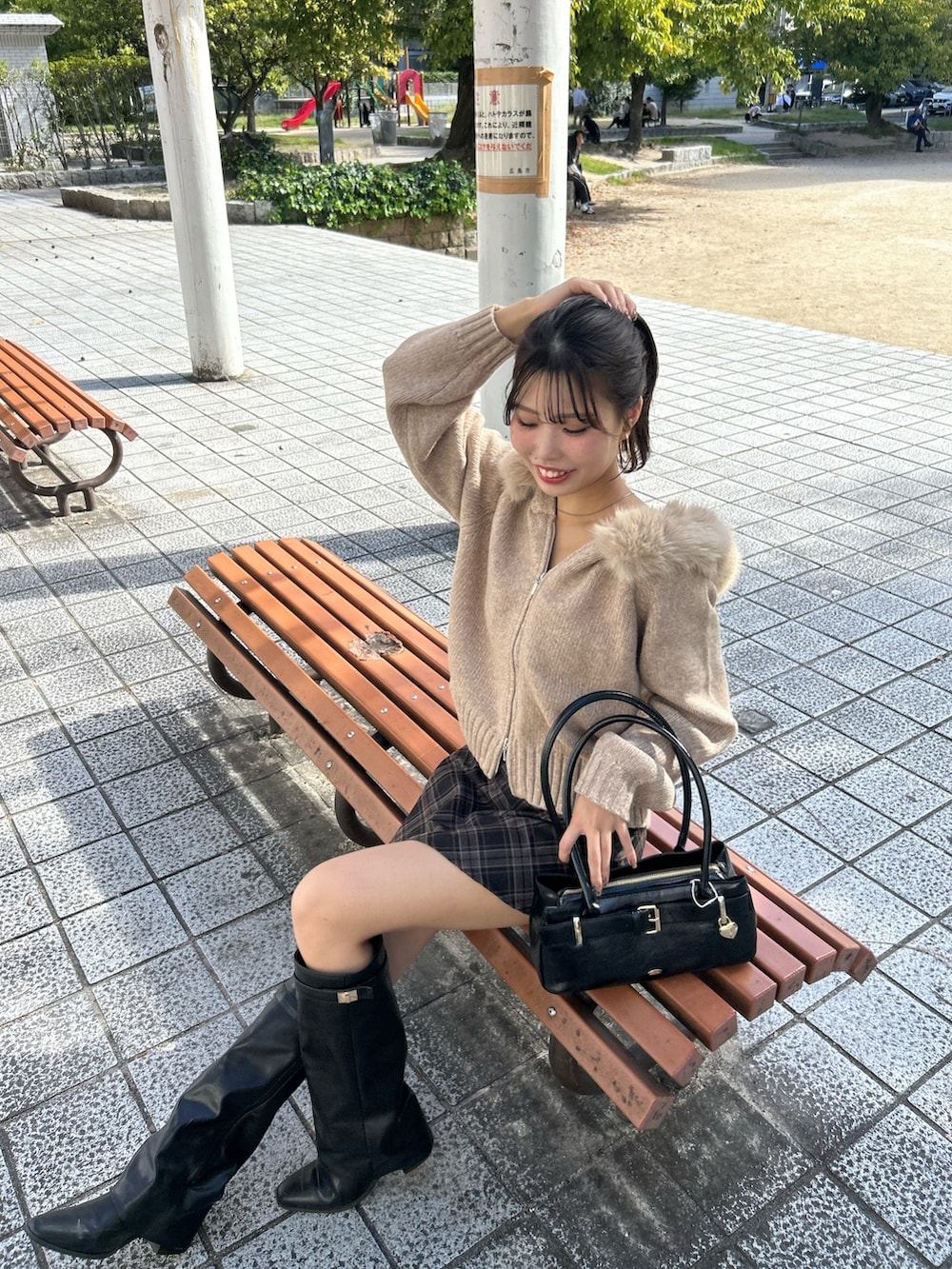 ベージュ系のニット/セーター、グレー系のスカート、ブラック系のボストンバッグを着用したレディースの秋コーディネートの6枚目の写真