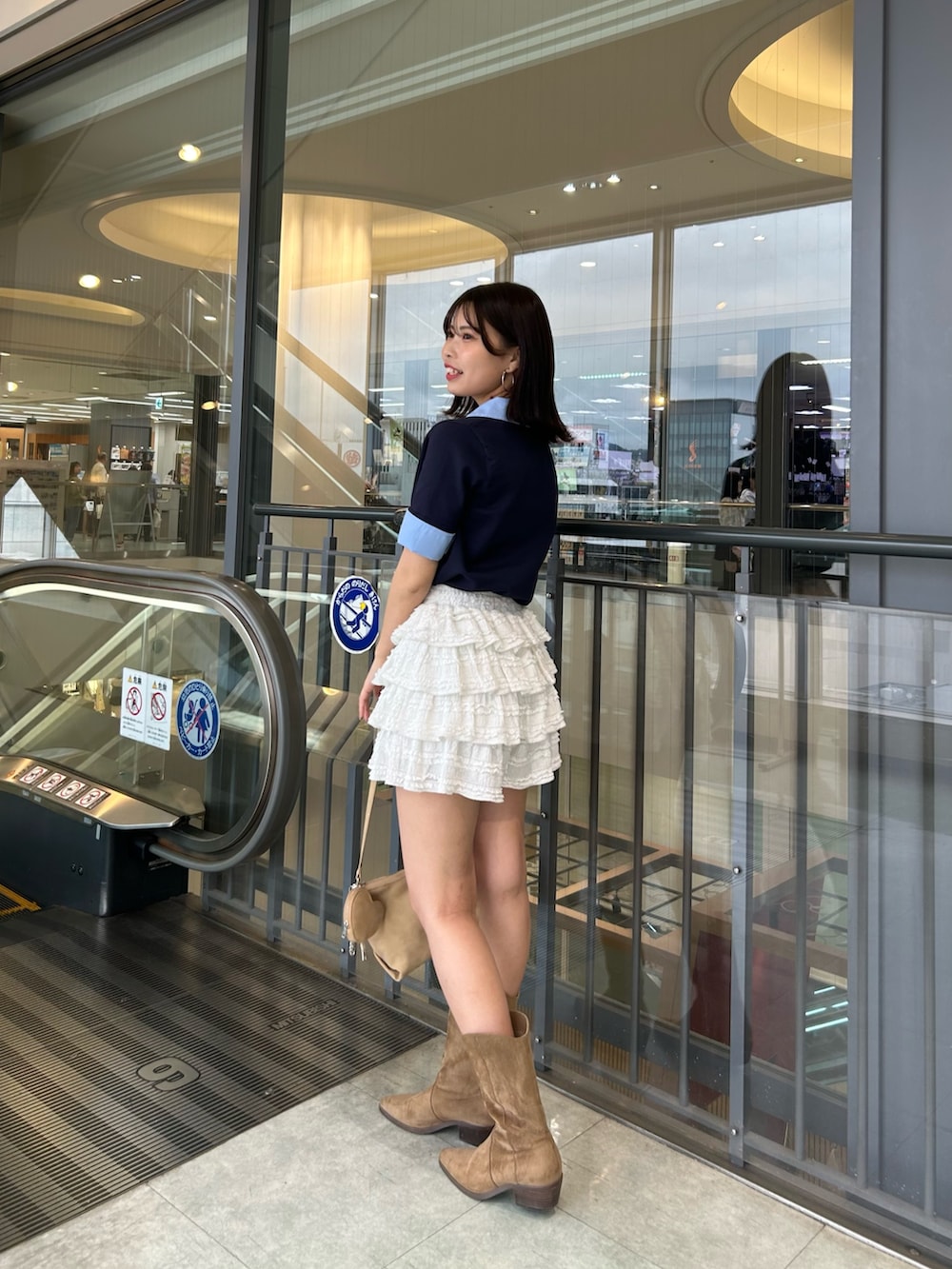 ブルー系のニット/セーター、ホワイト系のその他パンツ、ベージュ系のショルダーバッグを着用したレディースの春コーディネートの2枚目の写真