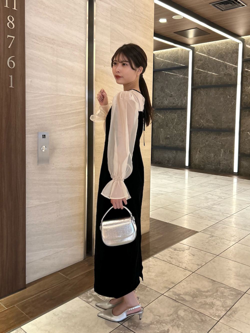 ブラック系のドレス、シルバー系のショルダーバッグ、シルバー系のパンプスを着用したレディースの春コーディネートの2枚目の写真