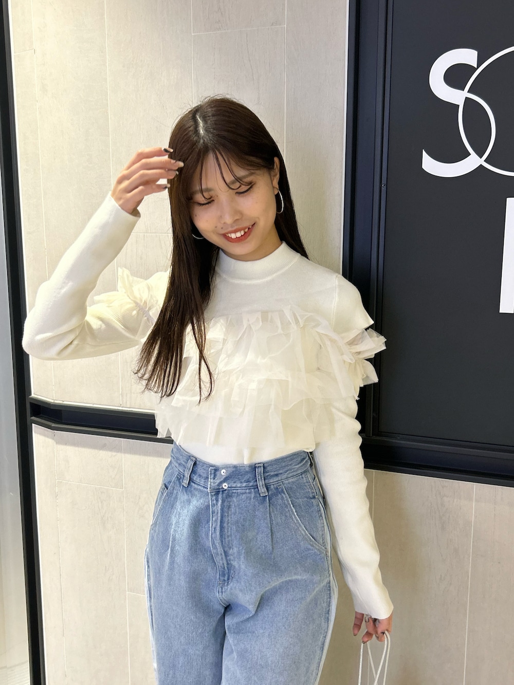 ブルー系のデニムパンツ、ホワイト系のニット/セーター、シルバー系のパンプスを着用したレディースの冬コーディネートの3枚目の写真