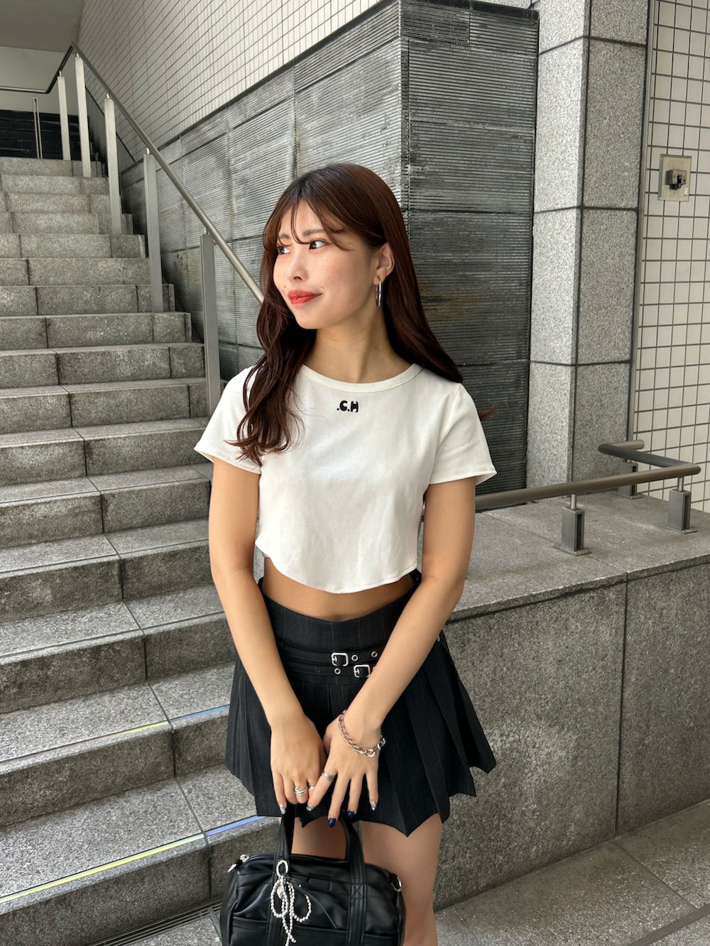 ホワイト系のTシャツ/カットソー、グレー系のスカート、ブラック系のボストンバッグを着用したレディースの夏コーディネートの4枚目の写真