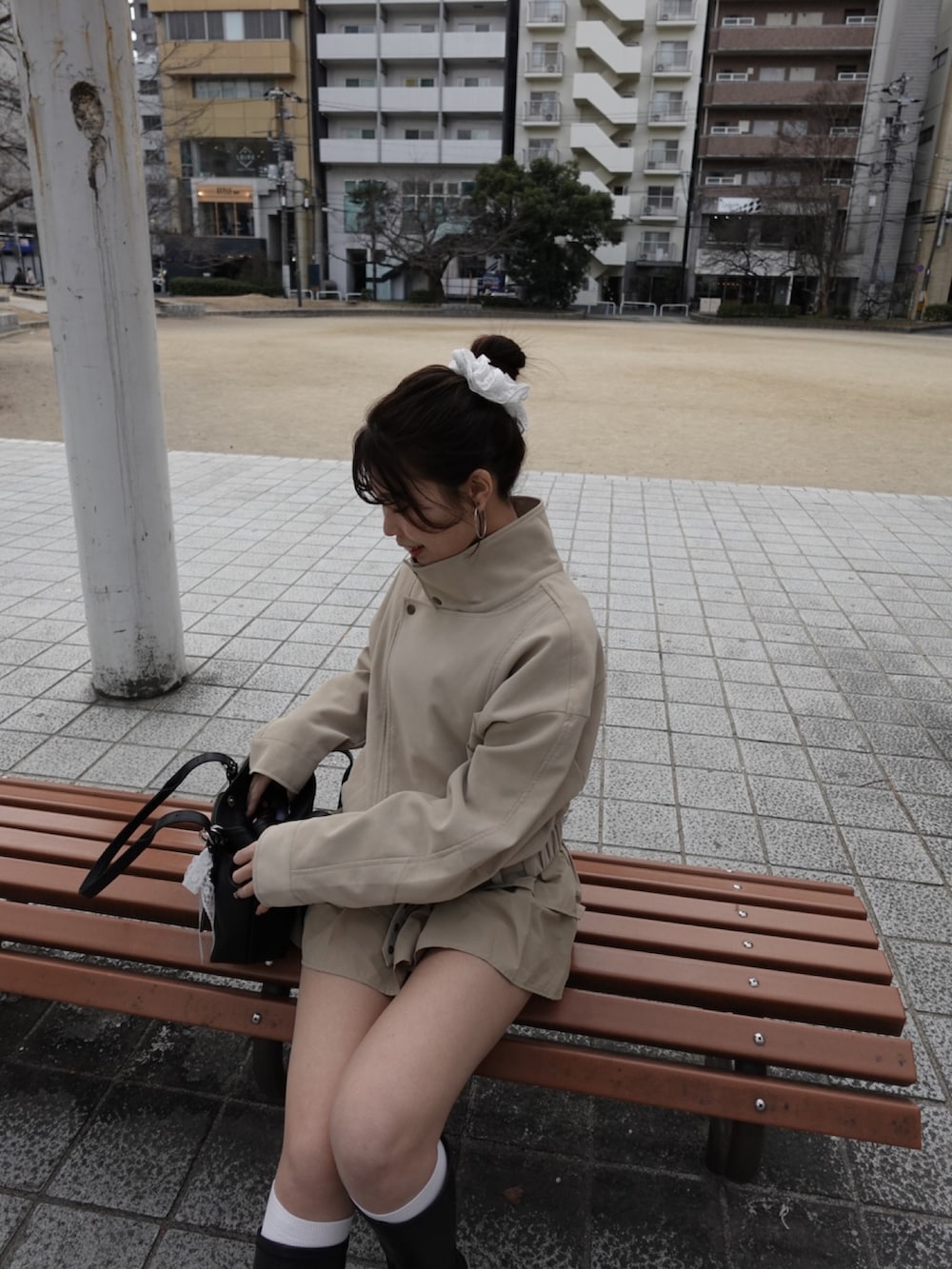 ホワイト系のその他アウター、ベージュ系のスカート、ブラック系のブーツを着用したレディースの冬コーディネートの3枚目の写真