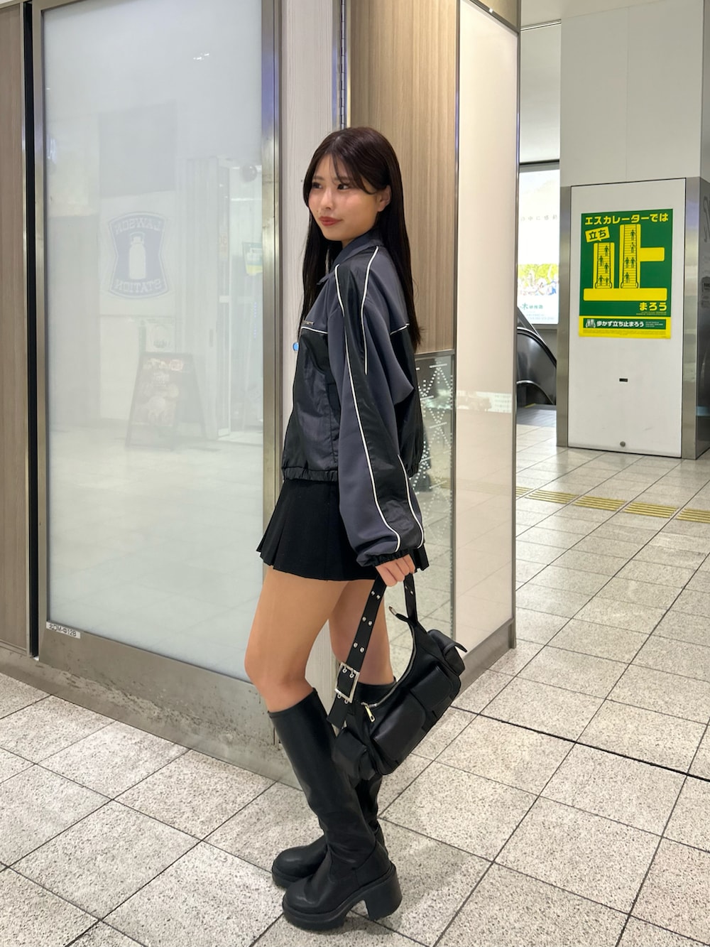 グレー系のブルゾン、ブラック系のブーツ、ブラック系のスカートを着用したレディースの冬コーディネートの2枚目の写真