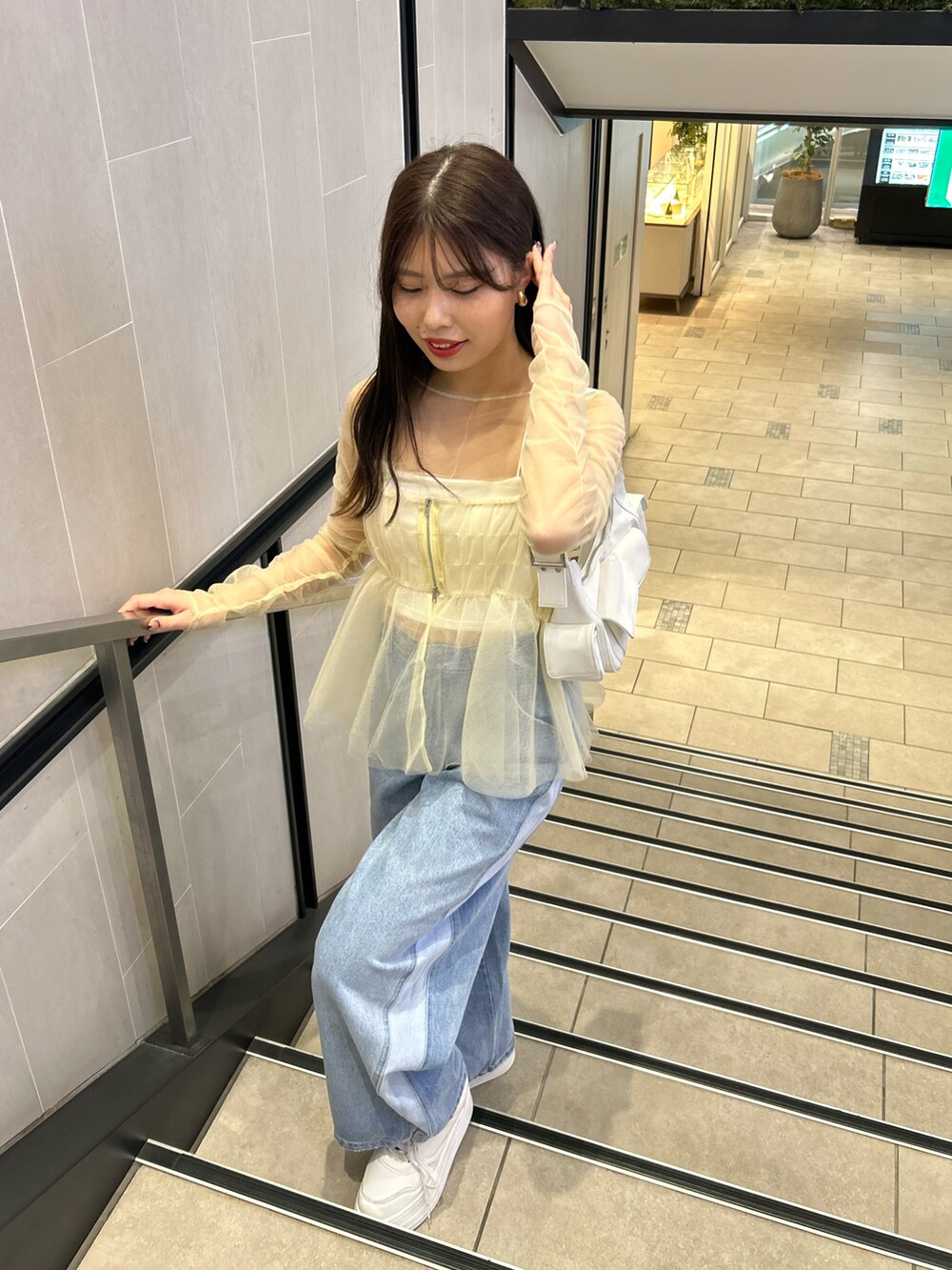 ブルー系のデニムパンツ、ホワイト系のシャツ/ブラウス、ホワイト系のキャミソールを着用したレディースの冬コーディネートの4枚目の写真