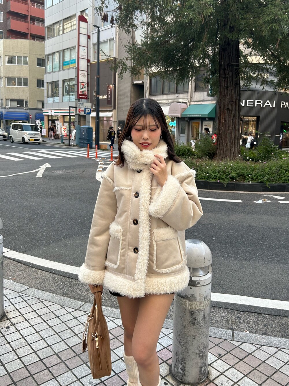 ホワイト系のその他アウター、ブラウン系のその他パンツ、ブラウン系のボストンバッグを着用したレディースの秋コーディネートの4枚目の写真