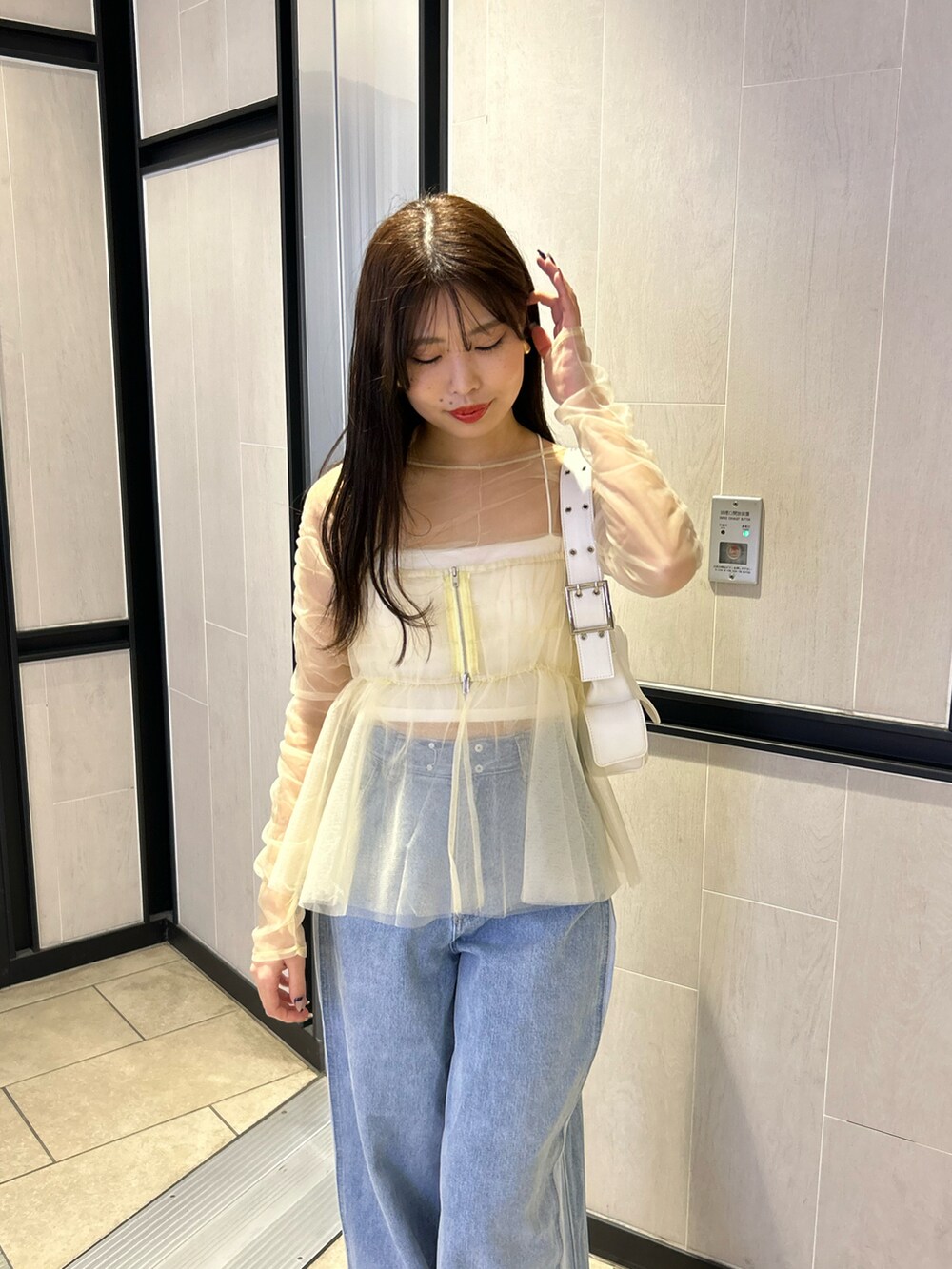 ブルー系のデニムパンツ、ホワイト系のシャツ/ブラウス、ホワイト系のキャミソールを着用したレディースの冬コーディネートの3枚目の写真